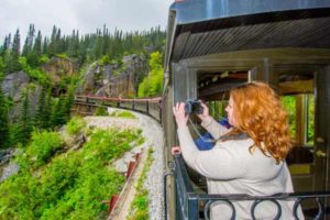 Tourist rides train in Skagway and shoots photos of scenery
