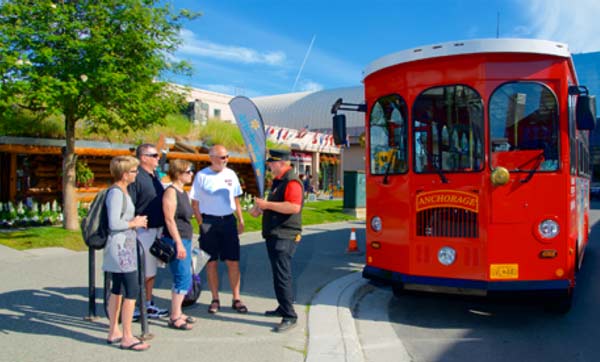 Visitors stand in front of Anchorage Trolley