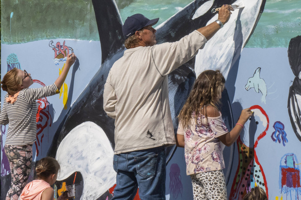 Wyland, a Laguna Beach-based artist, paints a mural with Southeast Alaska children